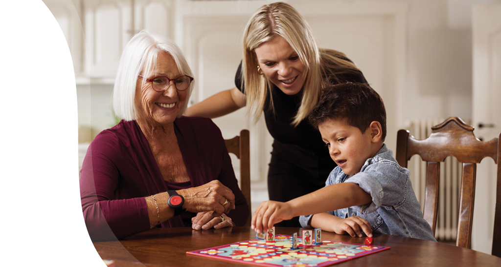 Dame met personenalarm geniet thuis van familiebezoek.