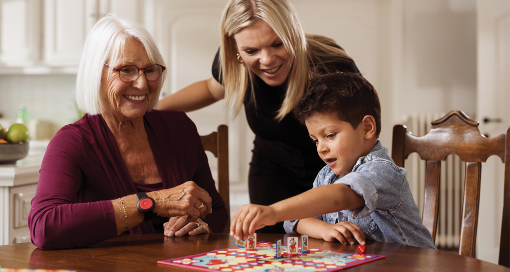 Dame met personenalarm geniet thuis van familiebezoek.